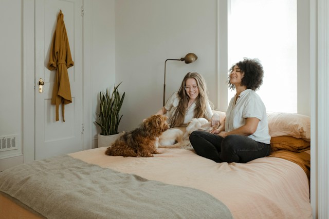 Couple relaxing on their bed at home with their dog Couple relaxing on their bed at home with their dog
