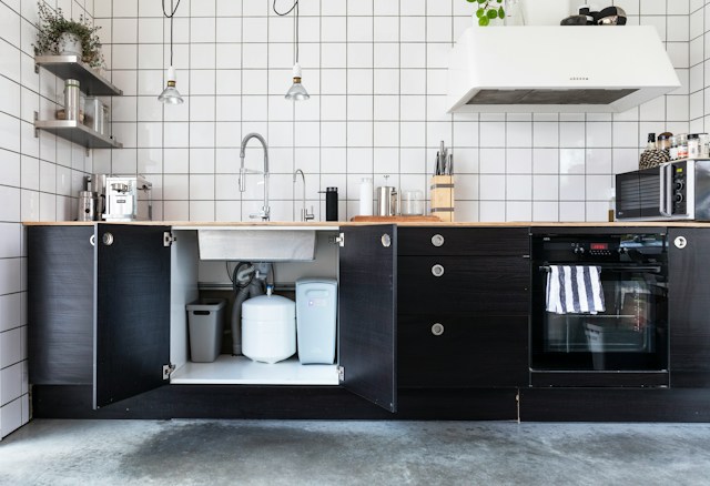 Kitchen with the cabinet doors under the sink open, a common spot to check after a leak Kitchen with the cabinet doors under the sink open, a common spot to check after a leak
